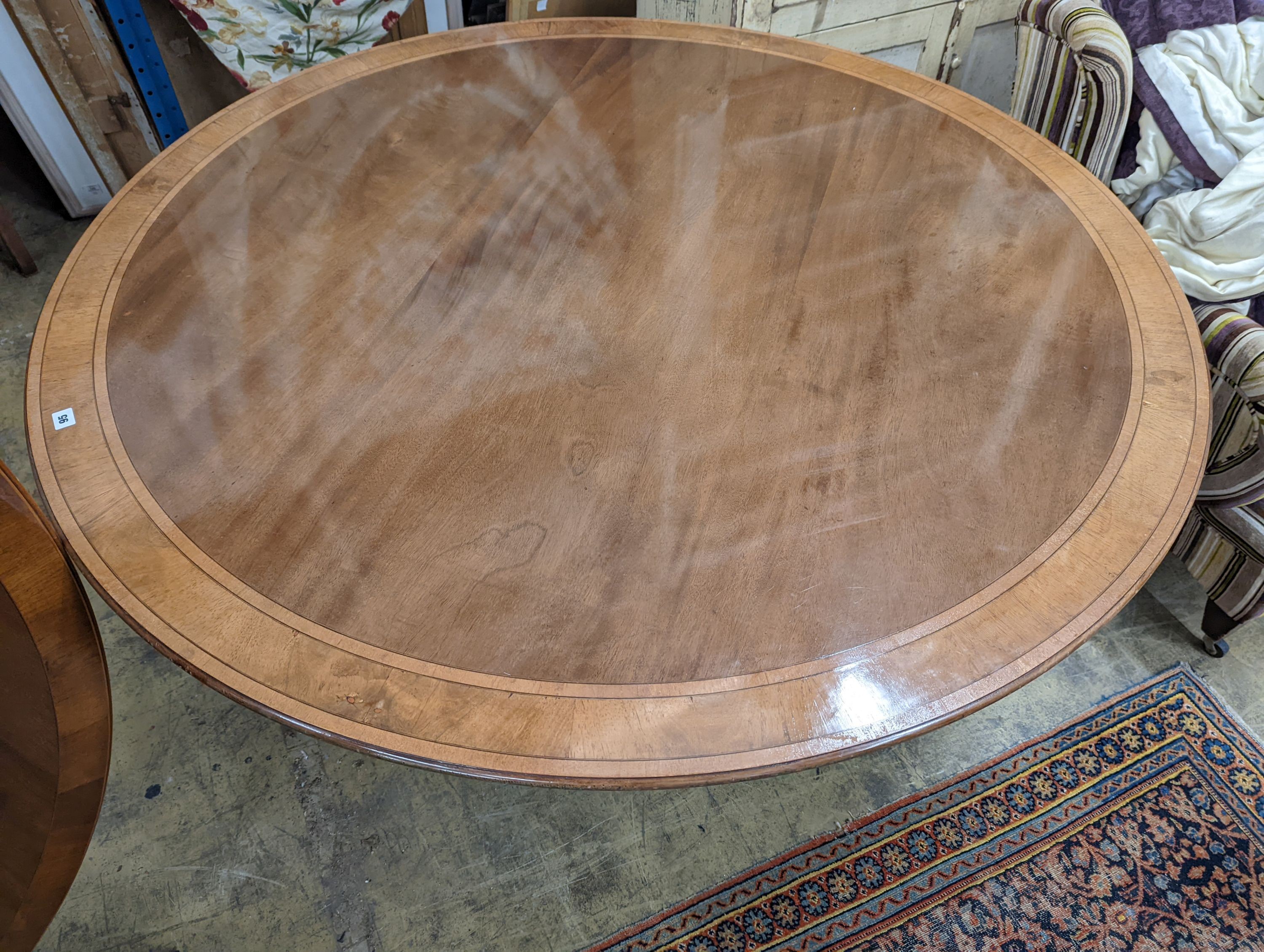 Attributed to William Tillman, a reproduction George III style banded mahogany circular pedestal tilt top dining table, diameter 160cm, height 72cm